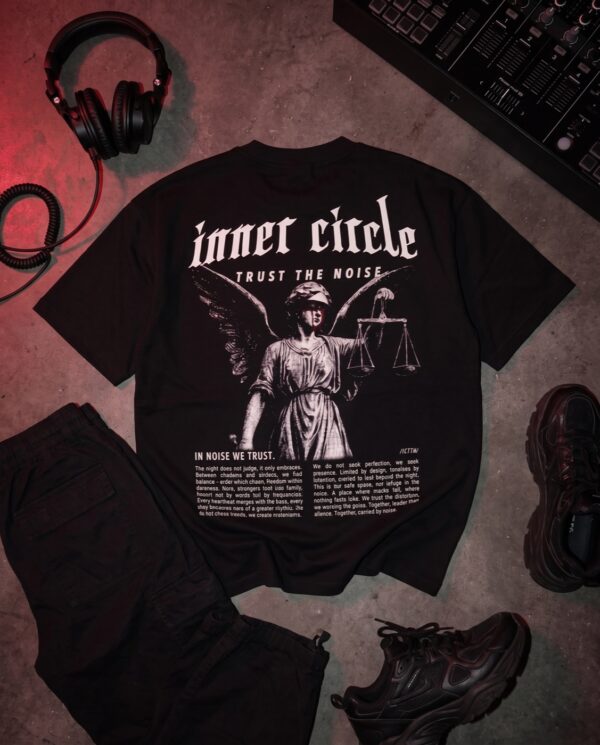 Justizia T-Shirt flach ausgelegt neben DJ-Kopfhoerer, Mixer und Sneakern