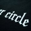 Makroaufnahme der gestickten Wordmark inner circle im Anschnitt